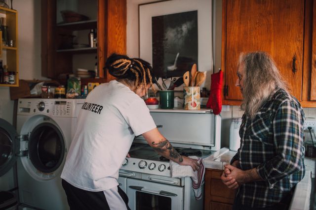 Volunteer helping a person in a kitchen