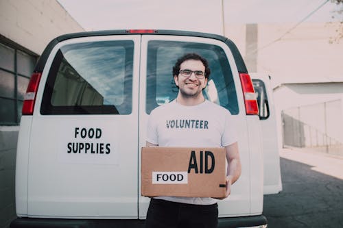 Free Man Carrying a Box of Food Stock Photo