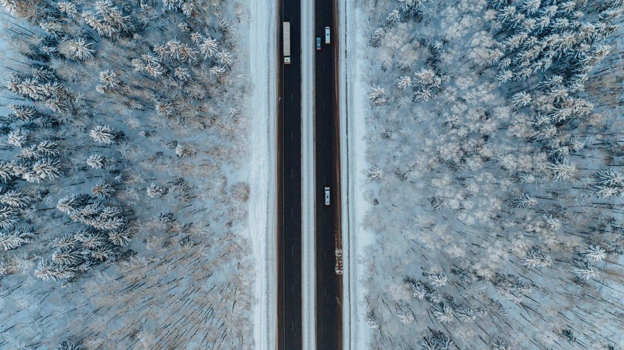 Aerial View of a Highway in a Frosted Forest · Free Stock Photo