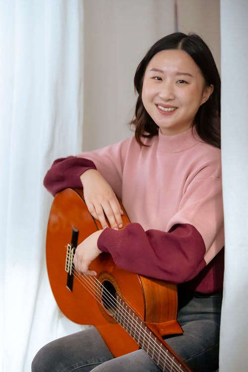 Smiling Asian musician with guitar
