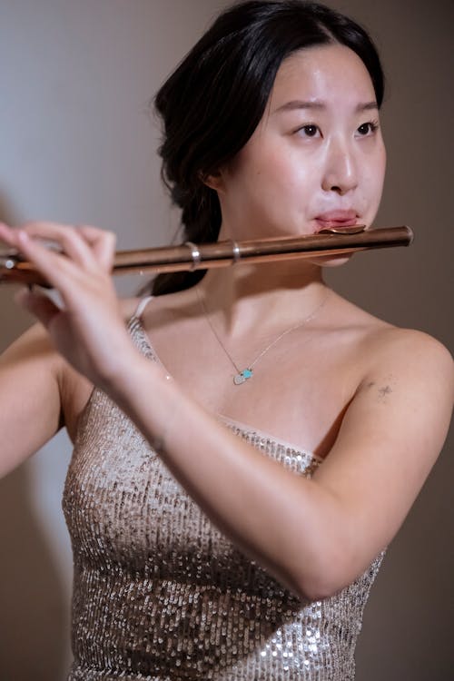 Focused Asian woman playing acoustic instrument