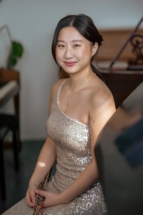 Smiling Asian woman with flute at event