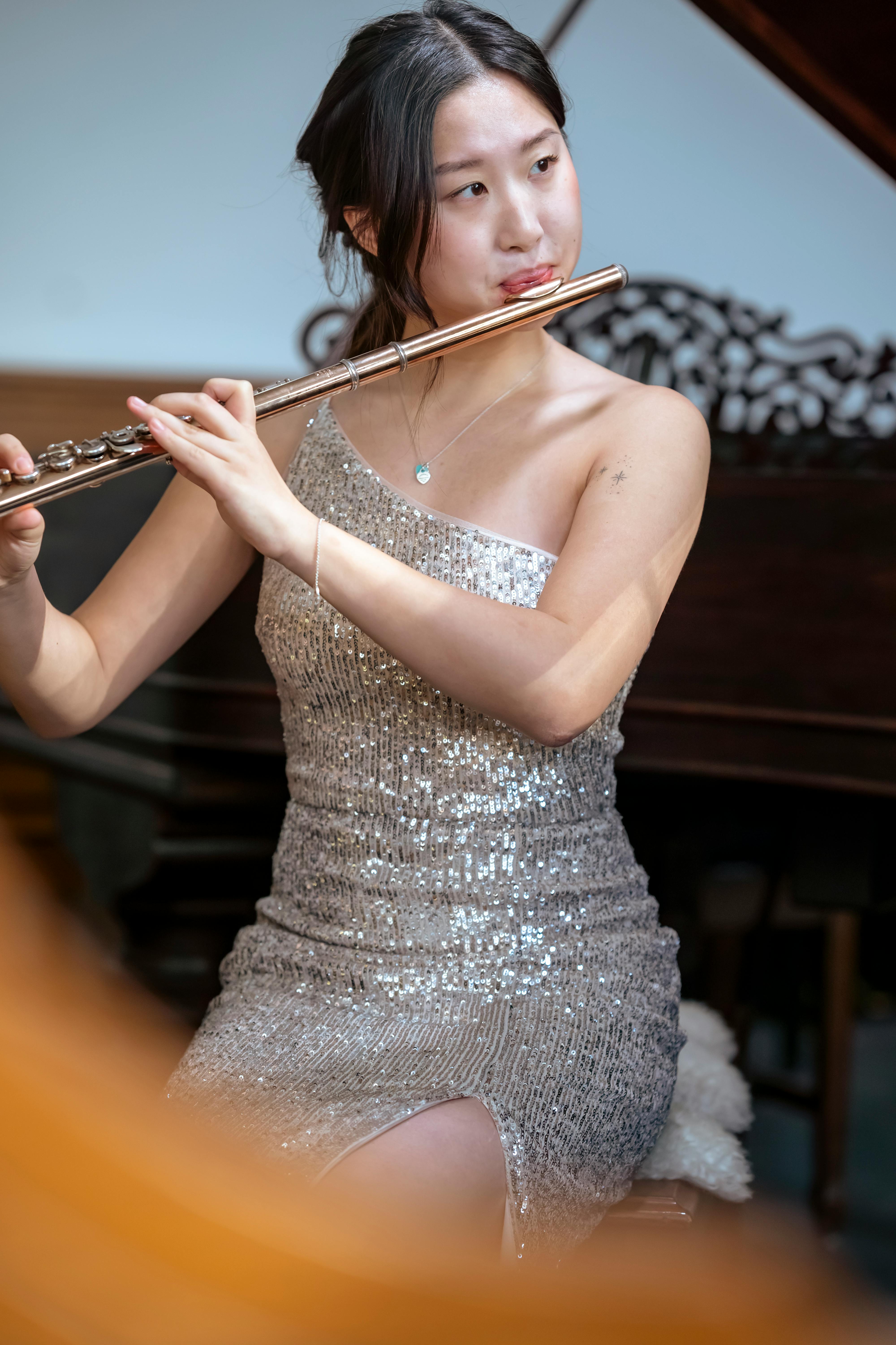 stylish asian woman playing flute