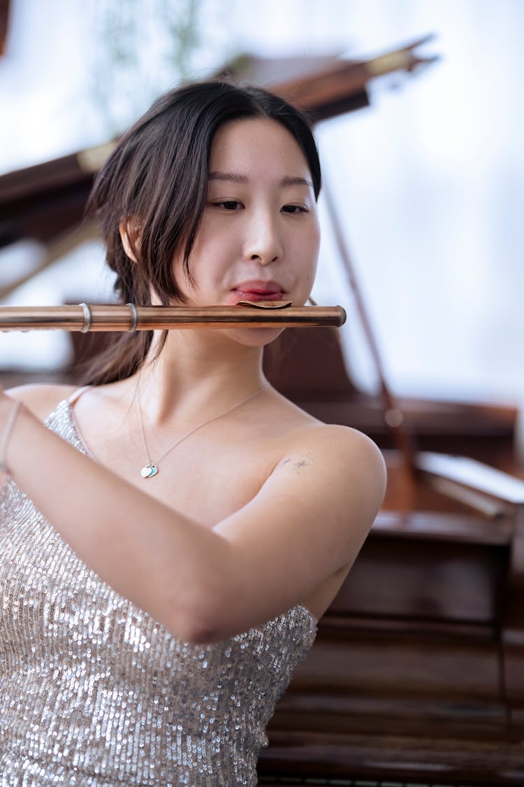 Focused Asian Female Musician Playing Flute