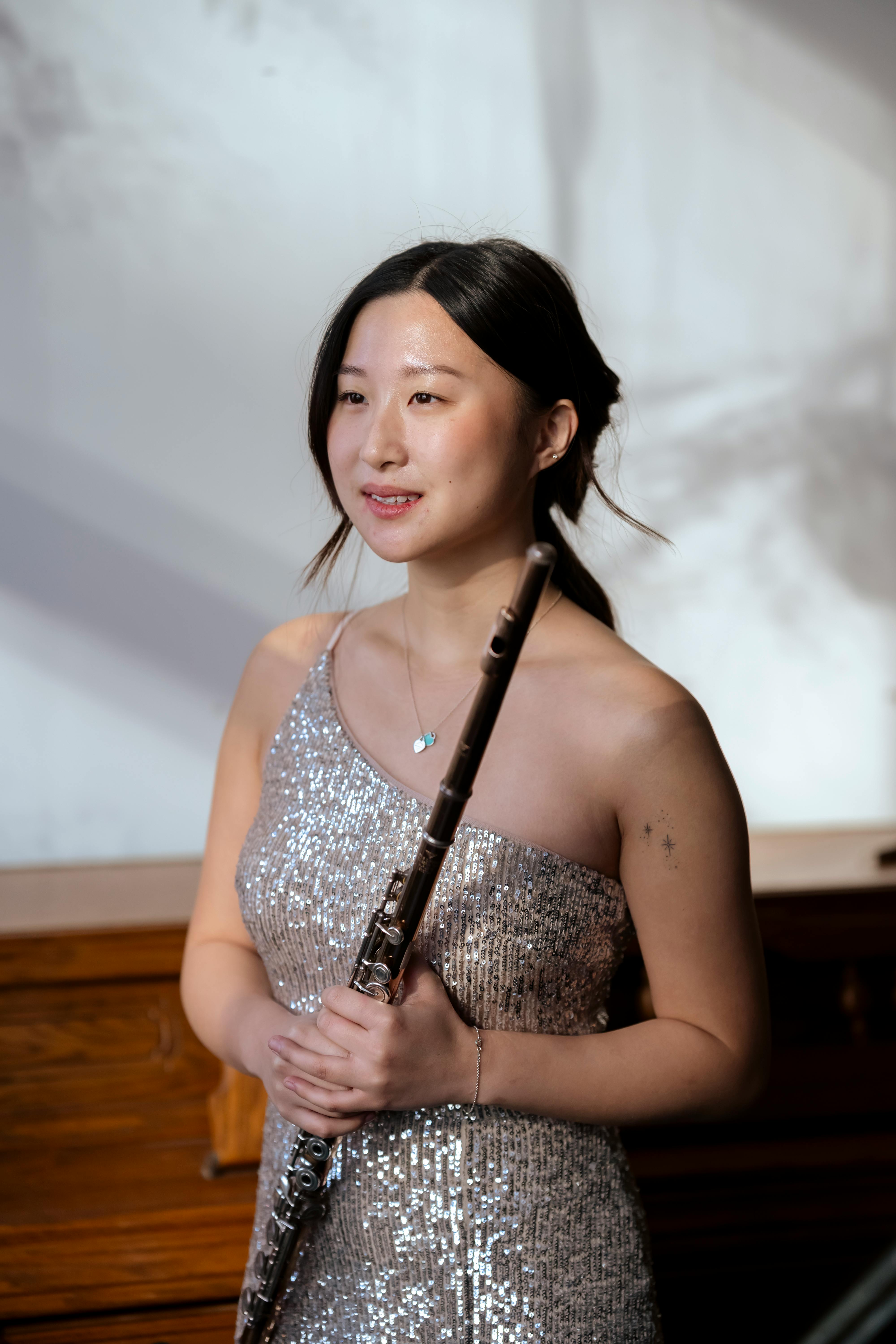 asian woman with flute in concert hall
