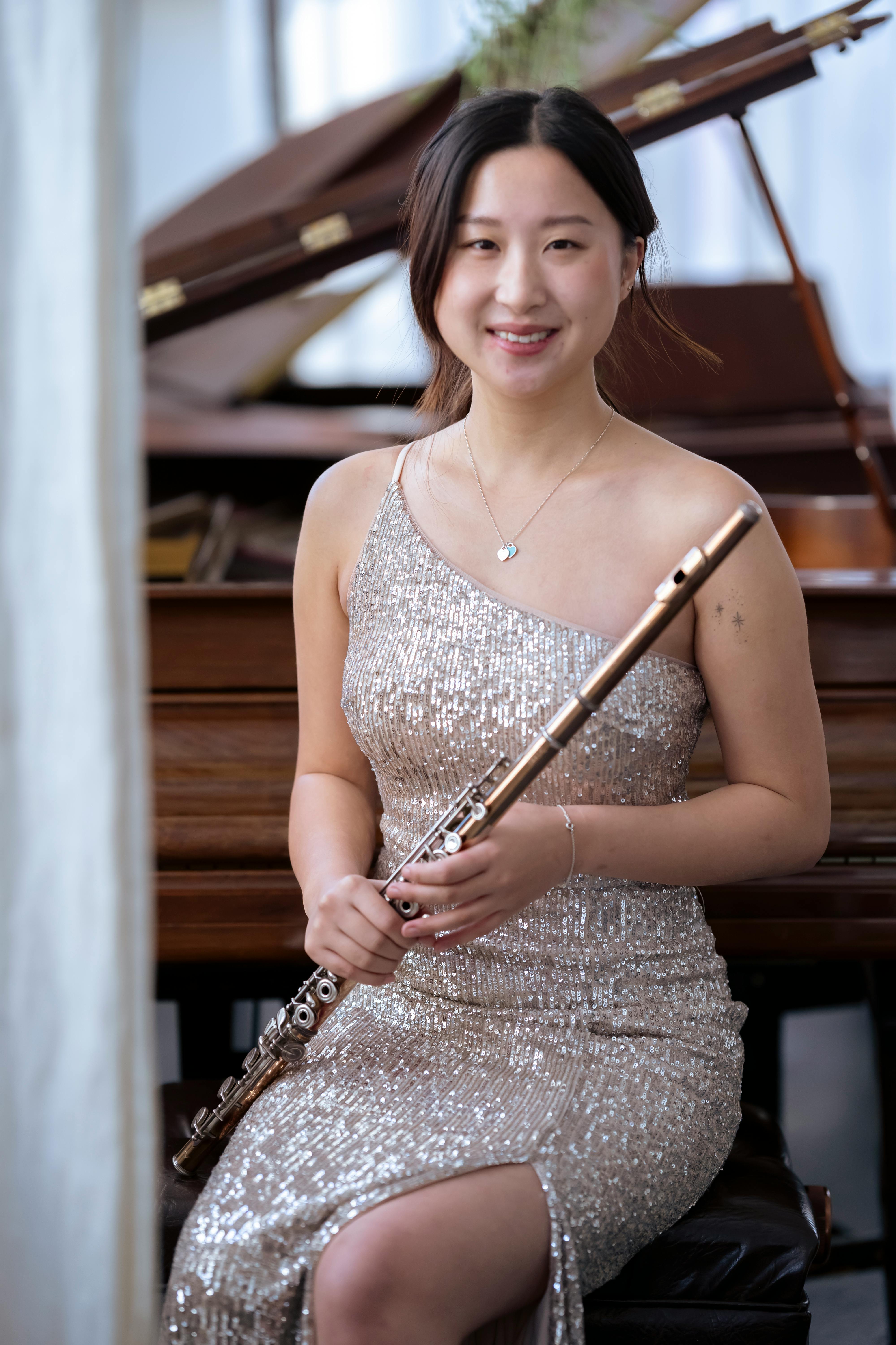 smiling asian woman in elegant dress with flute