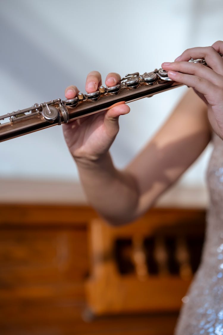 Woman Playing Flute In Light Room