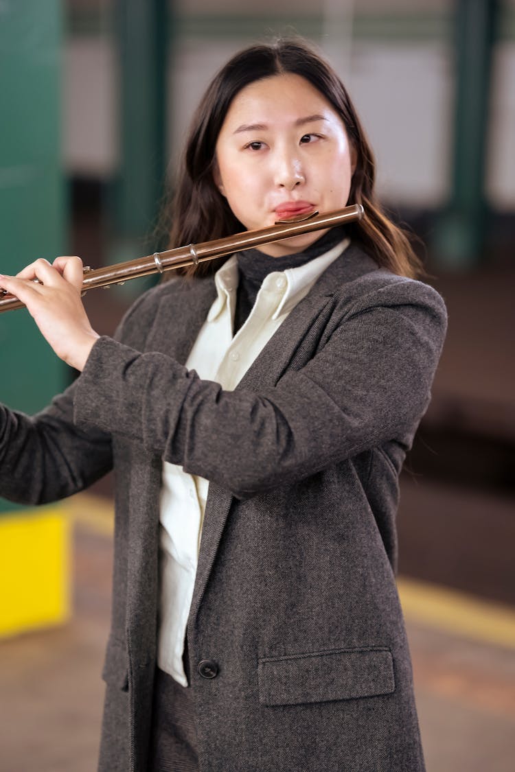 Young Asian Musician Playing Flute In Subway