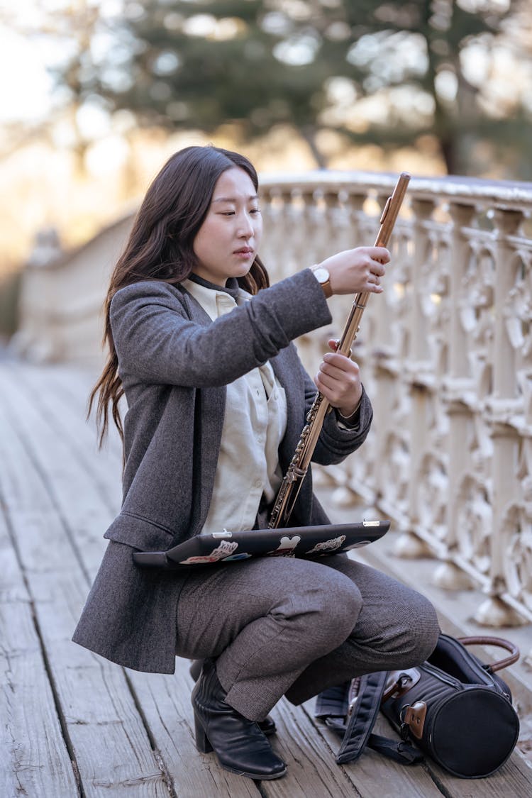 Young Asian Woman Joining Details Of Flute