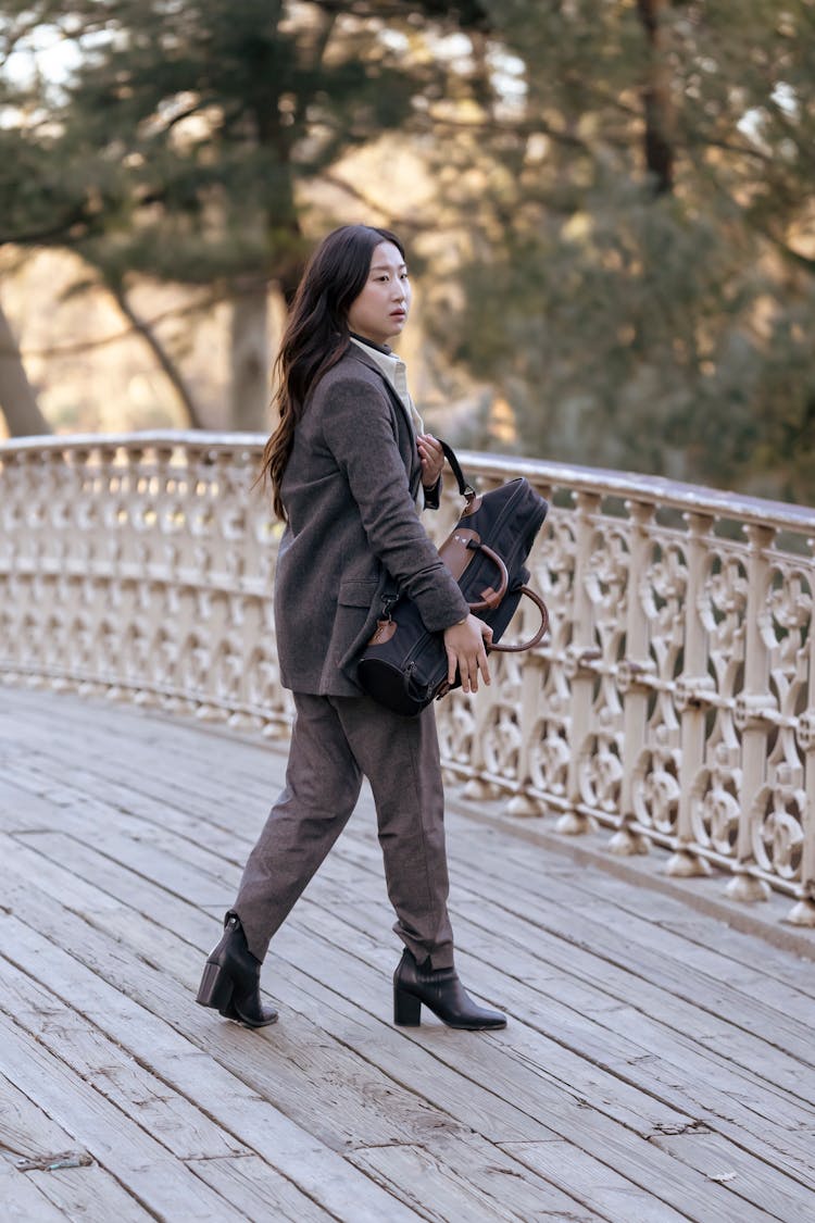 Woman Wearing A Brown Blazer Walking On A Wooden Deck