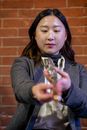 Serious Asian female musician preparing for acoustic performance on flute at spare time