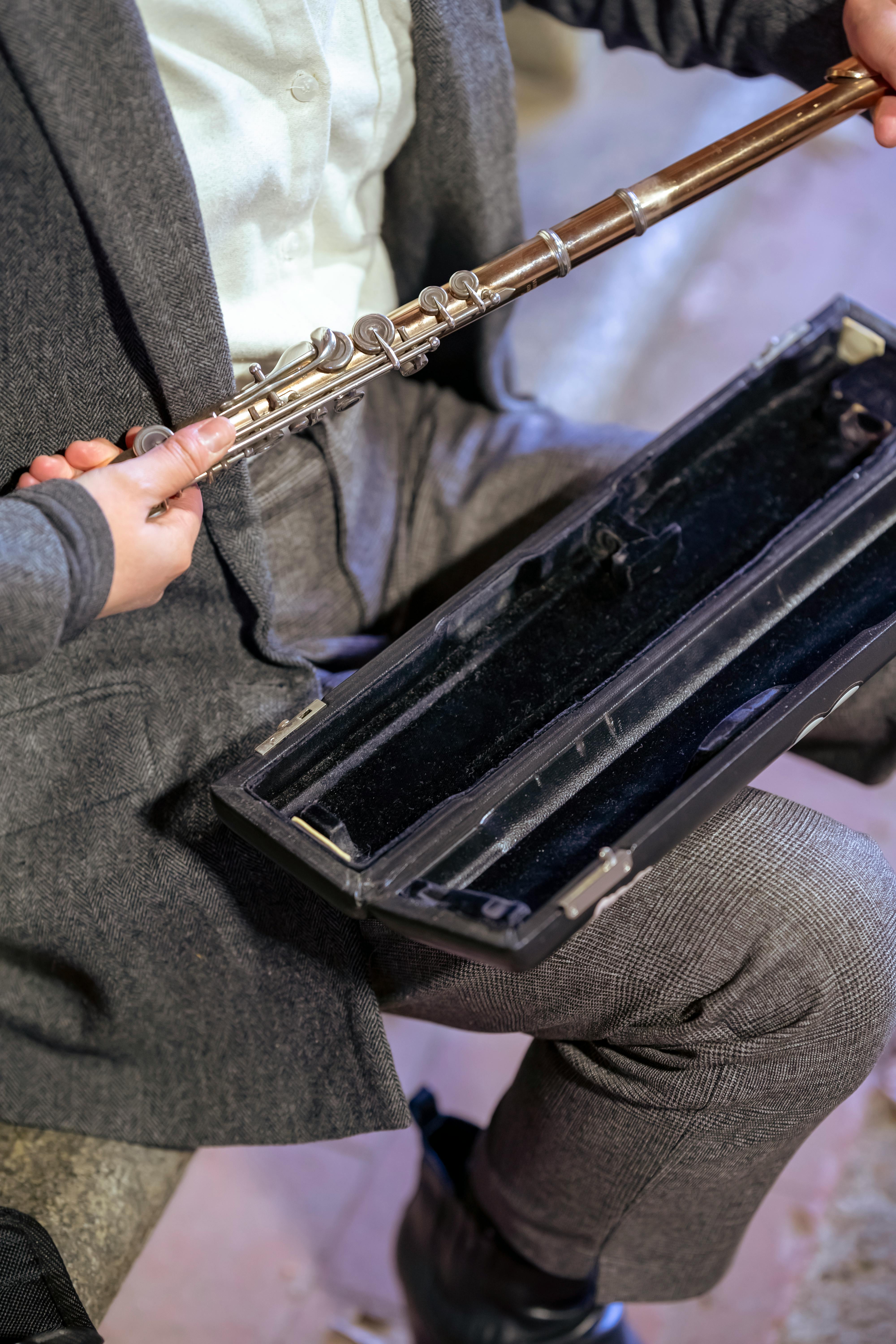 woman taking flute from case for music performance