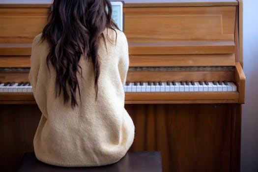 Unrecognizable young woman playing piano from back view, focusing on music practice.