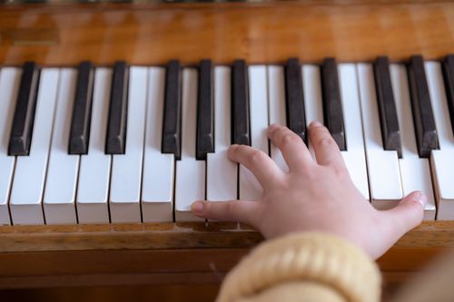 Free High angle of crop anonymous female pianist pressing keys of musical instrument during practice Stock Photo