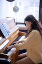 Asian female playing piano during rehearsal