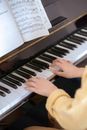 Woman playing piano with music book