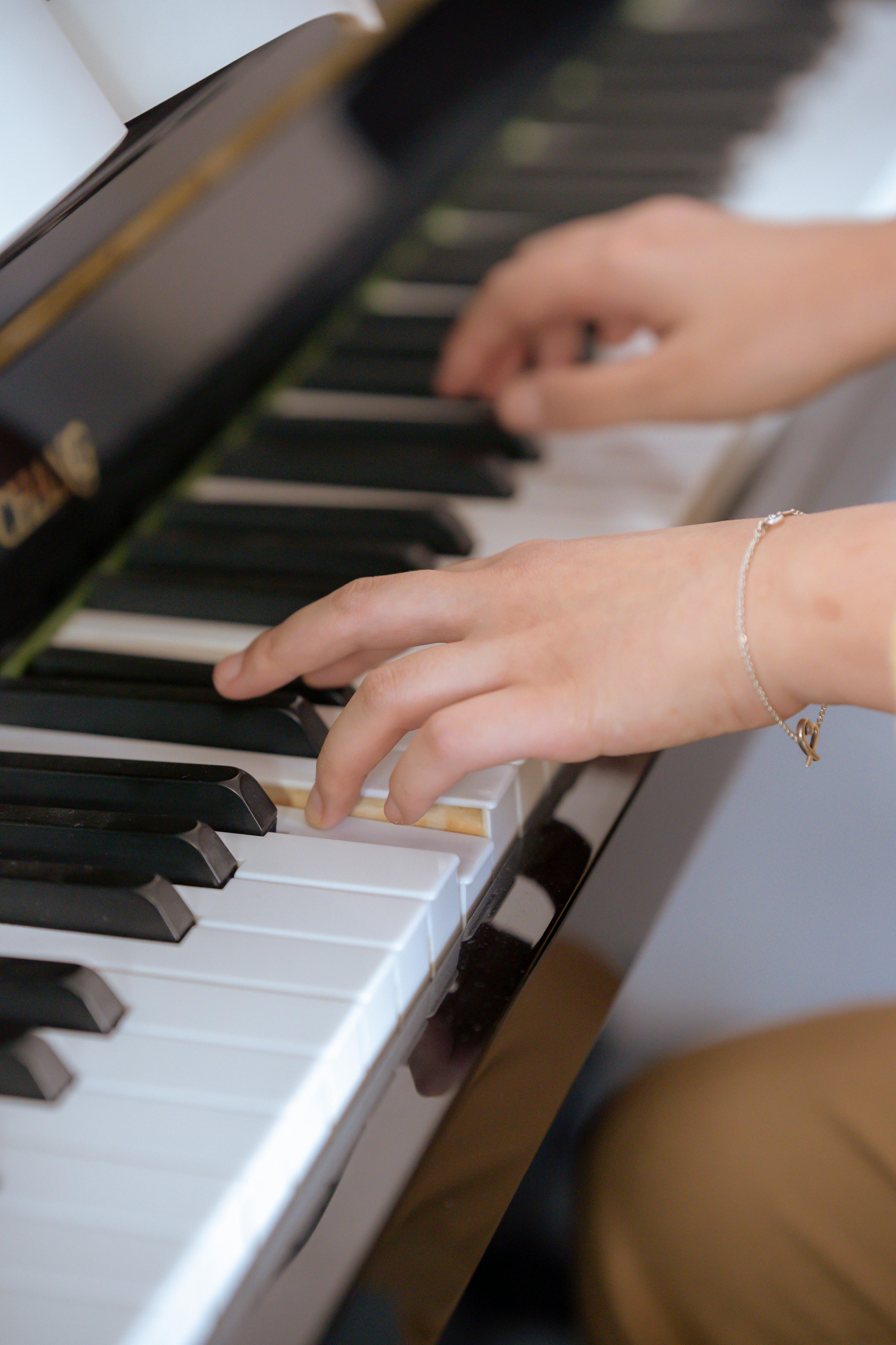 young lady gently pressing piano keys