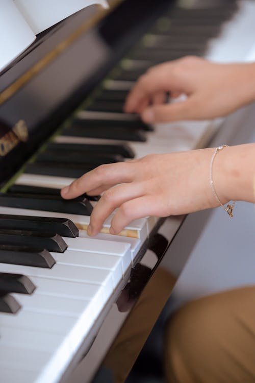 Young lady gently pressing piano keys