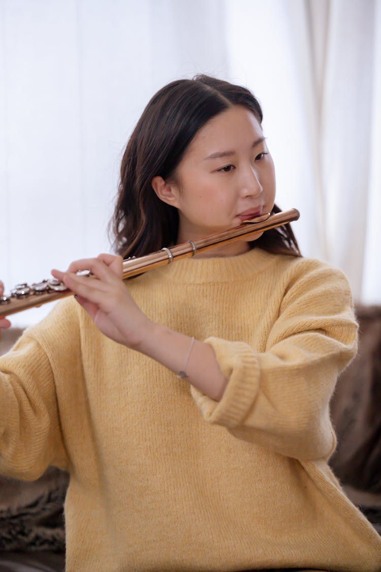 Young Asian Female Musician Playing Flute