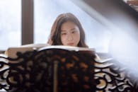 Calm Asian female musician behind ornamental music stand