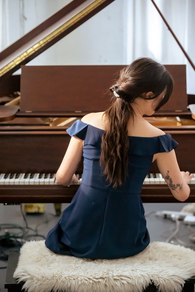 Faceless Woman Playing Piano In Studio