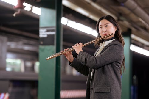 Ethnic woman playing flute on underground station