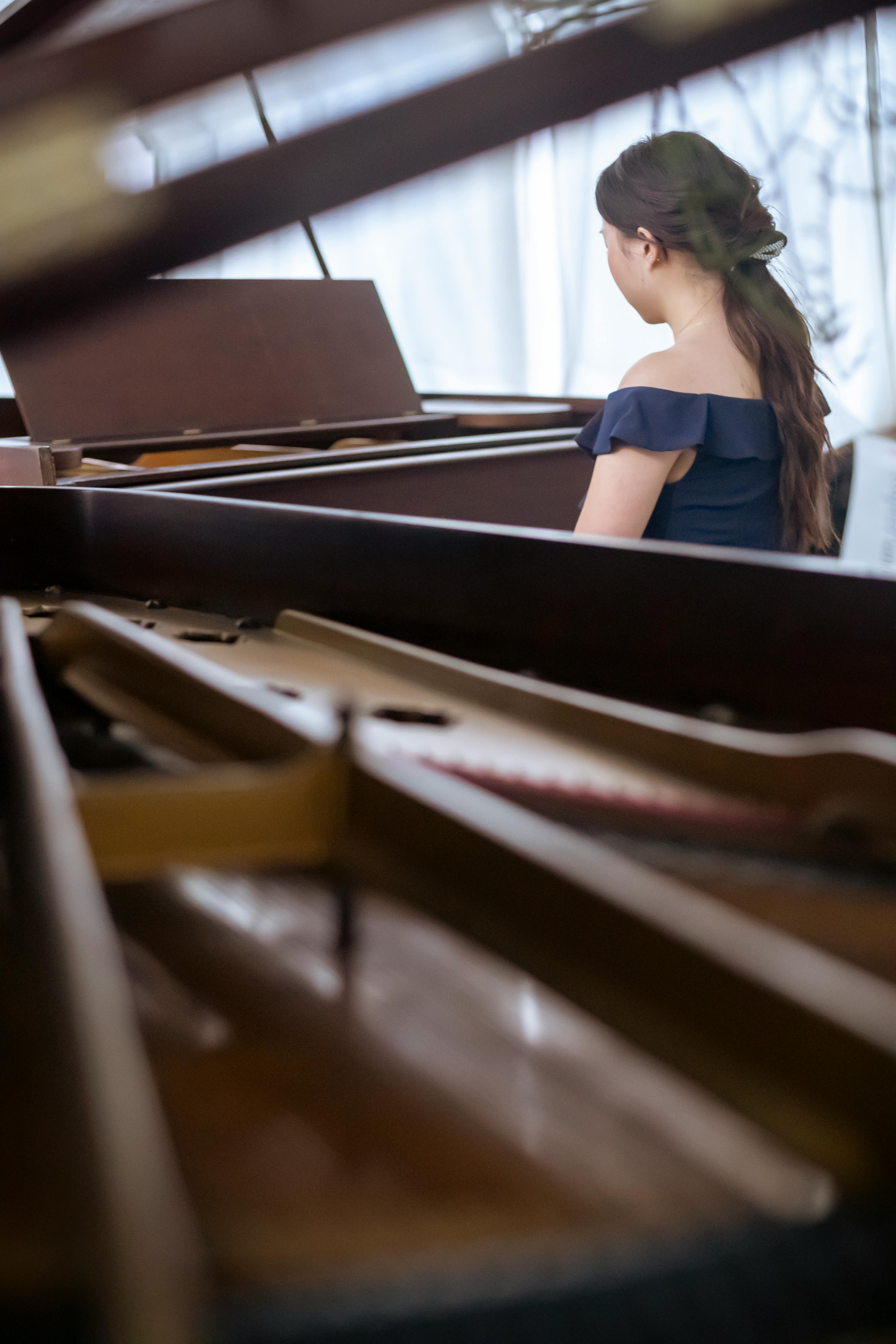 anonymous woman playing piano in classroom