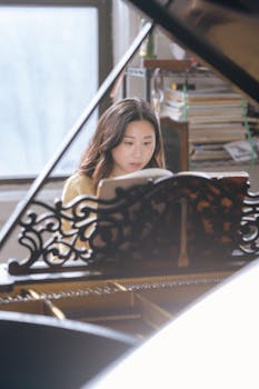 A young woman concentrating on playing the grand piano indoors during the day.