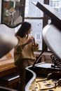 Asian musician playing flute between pianos during music lesson