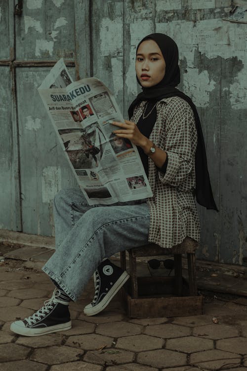 Woman Wearing Hijab Holding Newspaper