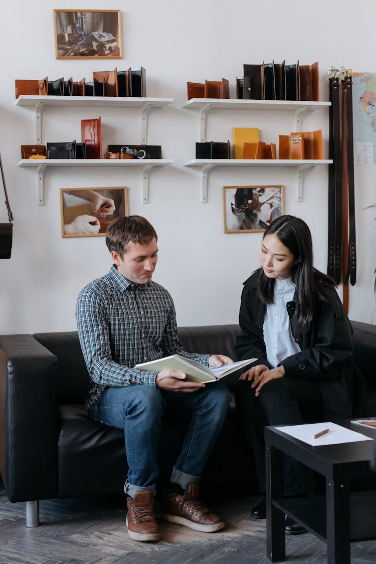 Woman And Man Sitting On Couch Together And Working