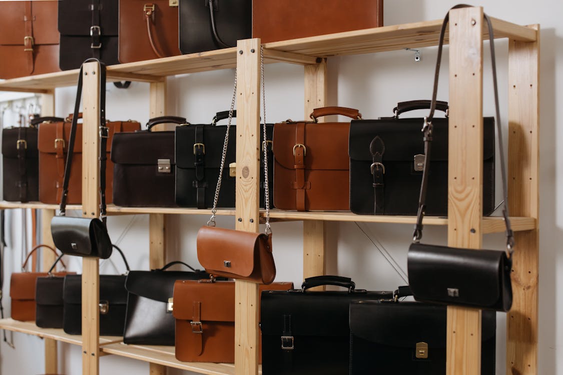 Leather Bags on Wooden Shelves · Free Stock Photo