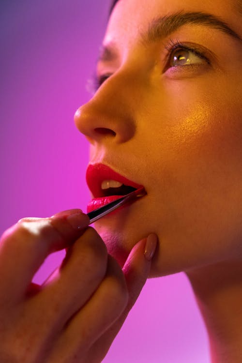 Free A Person Putting Lipstick To Woman's Lips Stock Photo