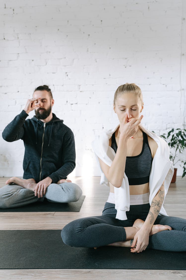 A Man And A Woman Meditating Practicing Breathing Control