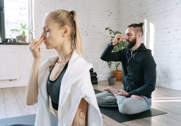 Wood table with porcelain mug, leather journal, brass pen, leather key ring, and a houseplant.