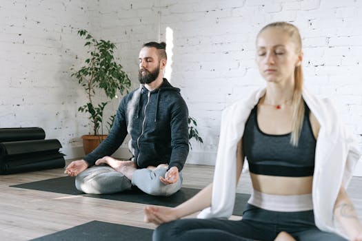 Two adults meditating in a calm, indoor setting enhancing mindfulness and wellness.