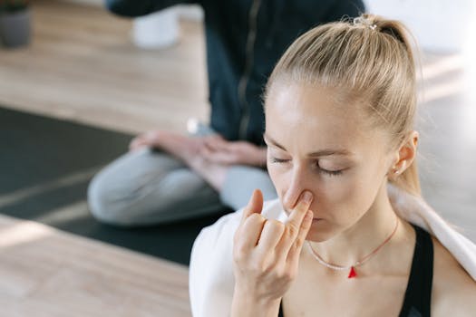 Woman meditating indoors practicing yoga breathing techniques with focused concentration.