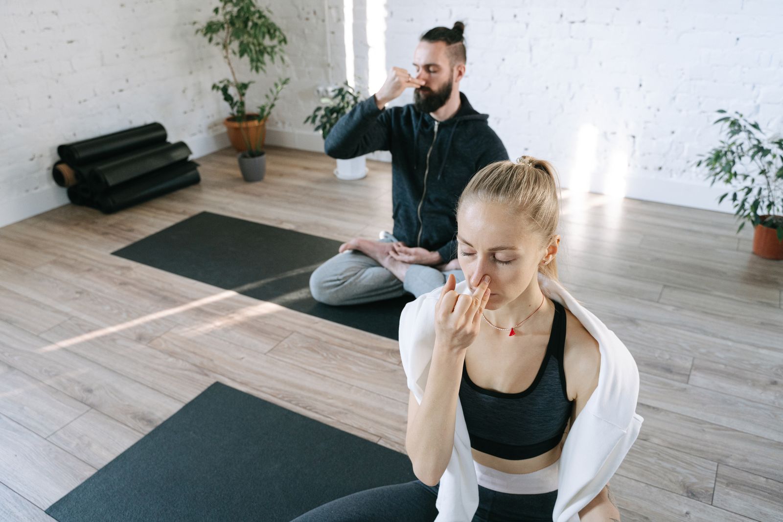 Woman sitting cross-legged in meditation pose with eyes closed during a quiet morning session