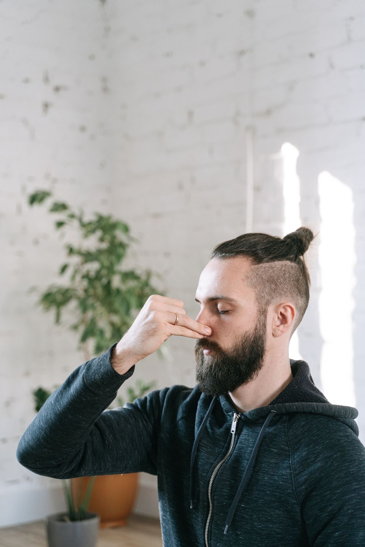 Man with eyes closed practicing calm breathing in a quiet indoor space