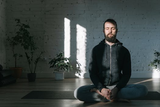 Adult man in a meditative pose indoors, embracing tranquility and mindfulness.