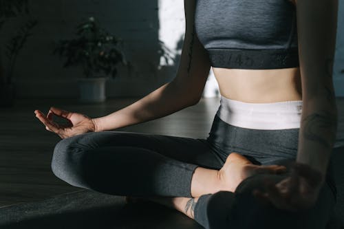 A Woman in Active Wear Meditating in Lotus Position