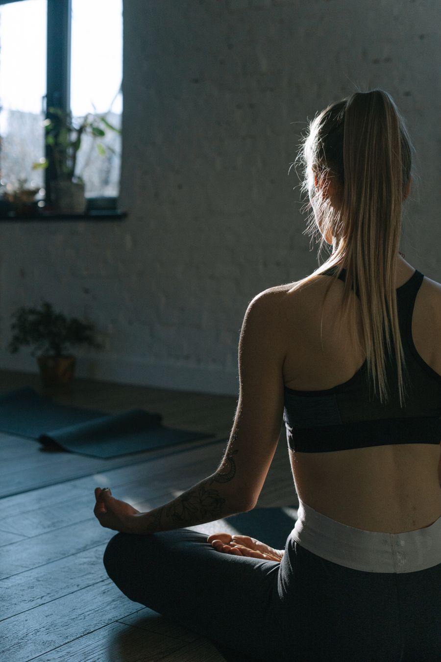 Mujer meditando de espaldas, en calma