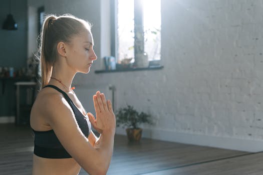 Adult woman meditating in a calm indoor space, practicing yoga and mindfulness.