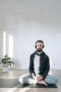 A Man Doing Yoga while Listening to Music