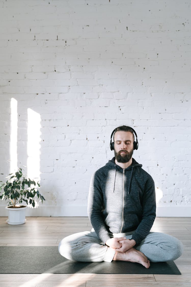 A Man Doing Yoga While Listening To Music