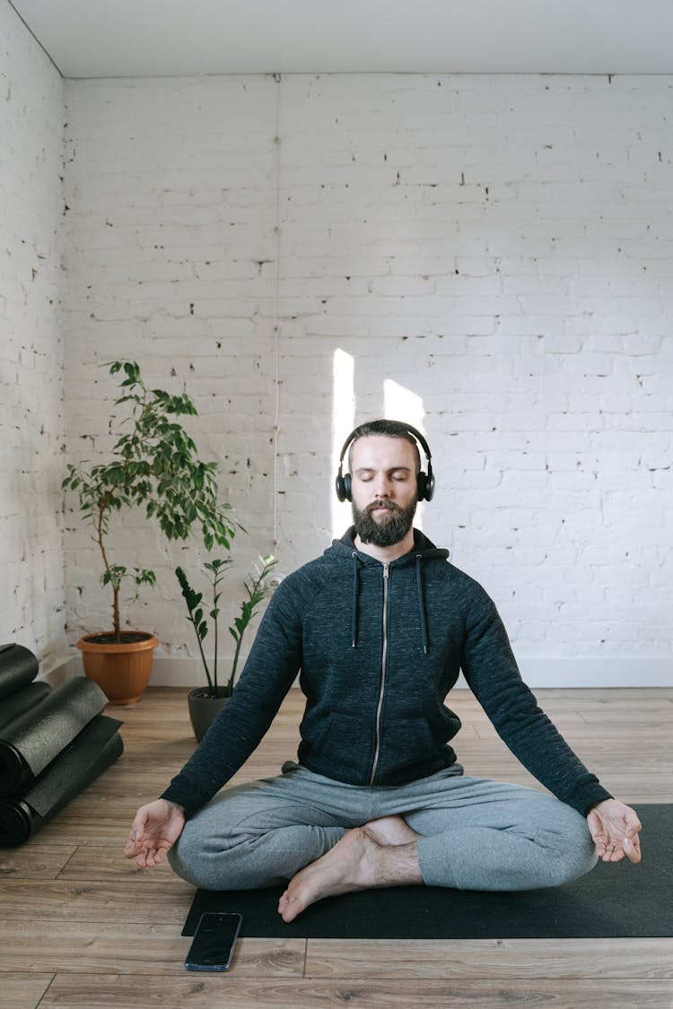 A Man Listening To Music While Doing Yoga