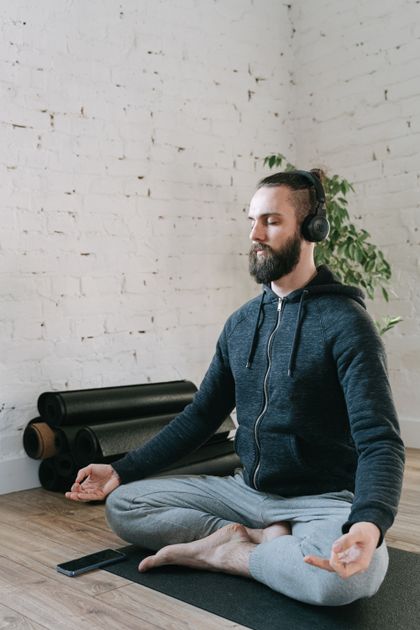 Man meditating with headphones in a quiet studio — photo by Ivan S on Pexels