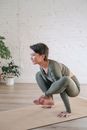 Woman in Gray Shirt and Gray Pants Sitting on Brown Wooden Floor