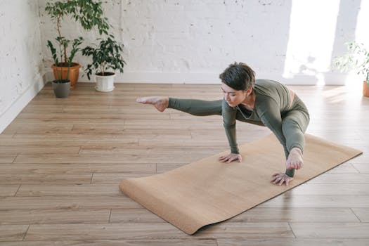 A woman in a yoga pose indoors, showcasing flexibility and strength on a mat.