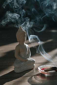 Buddha statue with serene smoke from holy wood, creating a calm ambiance.